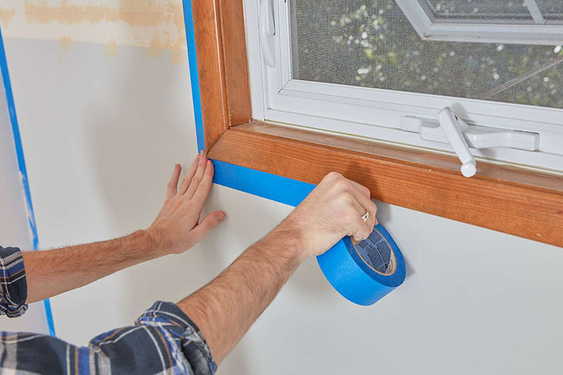 Painter masking around window frame | McAuliffe Painting