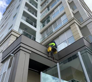 Painter abseiling down apartment building | McAuliffe Painting